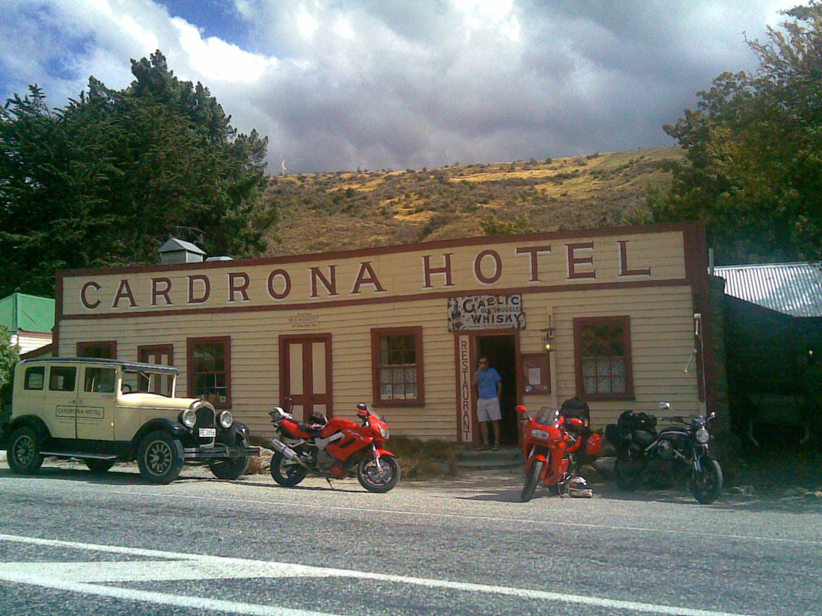 The historic Cardrona Hotel with motorcycles and vintage car parked outside Cardrona Valley New Zealand