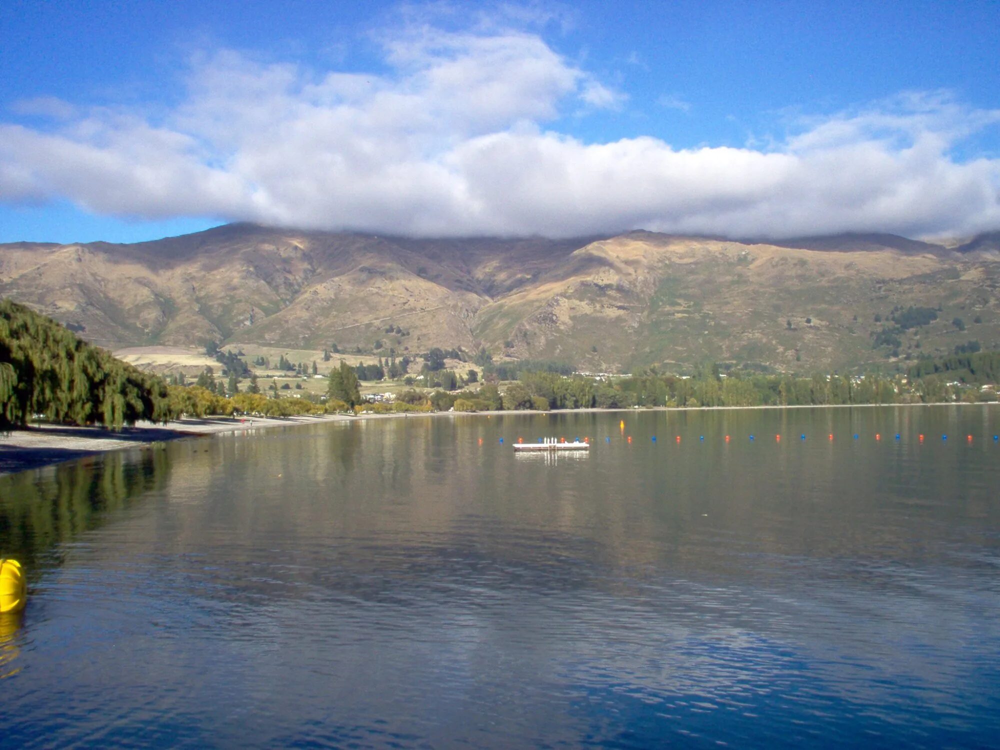 Lake Wanaka waterfront with mountains reflected in calm water New Zealand