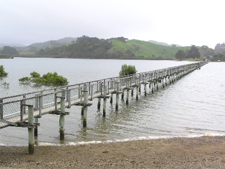 Long footbridge crossing a river in the Southland countryside New Zealand