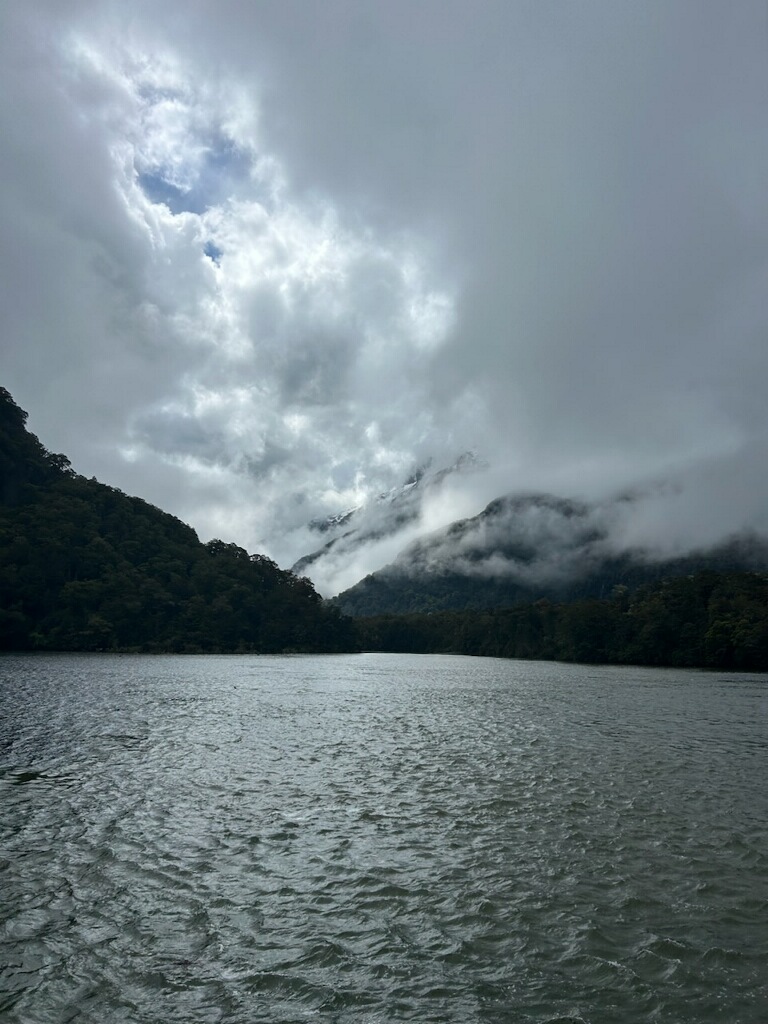 Moody overcast conditions on Milford Sound with mist clinging to mountains Fiordland New Zealand