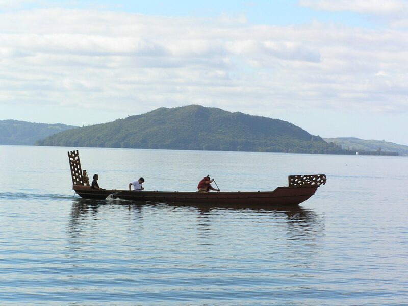 Maori waka canoe on Lake Rotorua with Mokoia Island New Zealand
