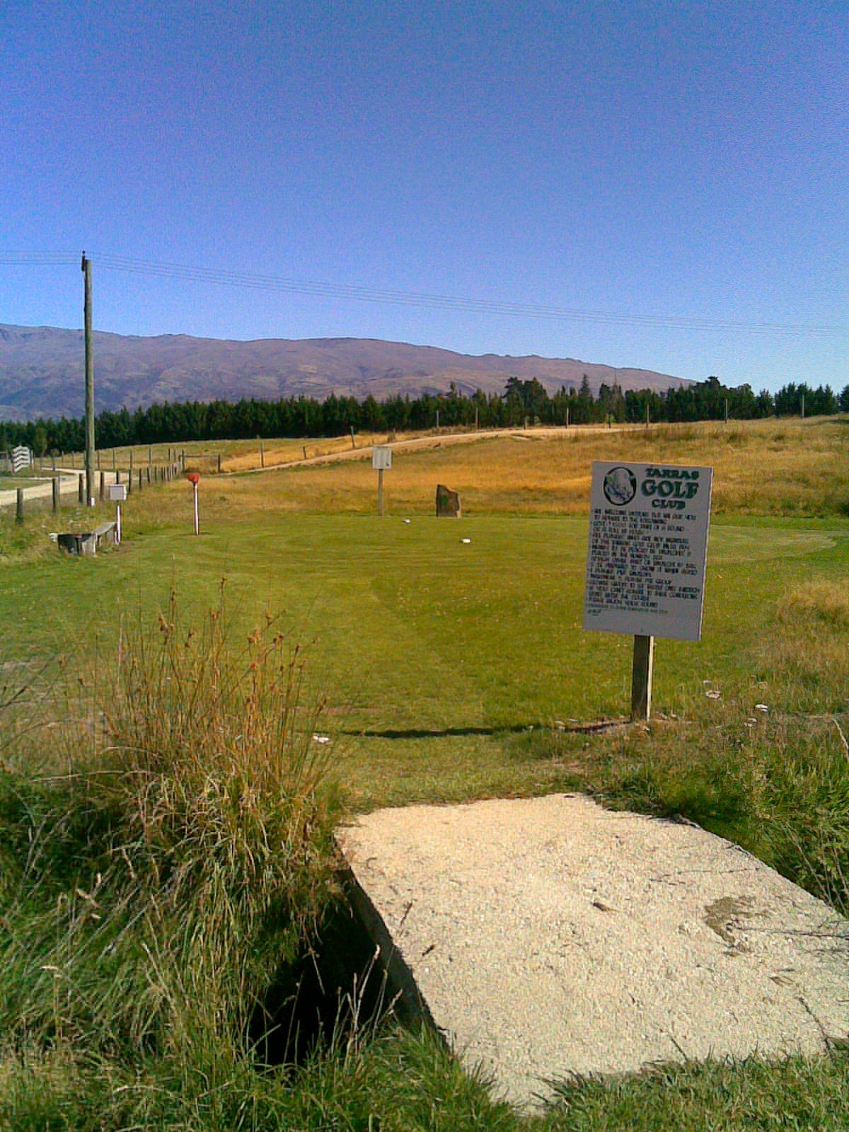 First tee at Tarras Golf Club with rules board and honesty box Central Otago New Zealand