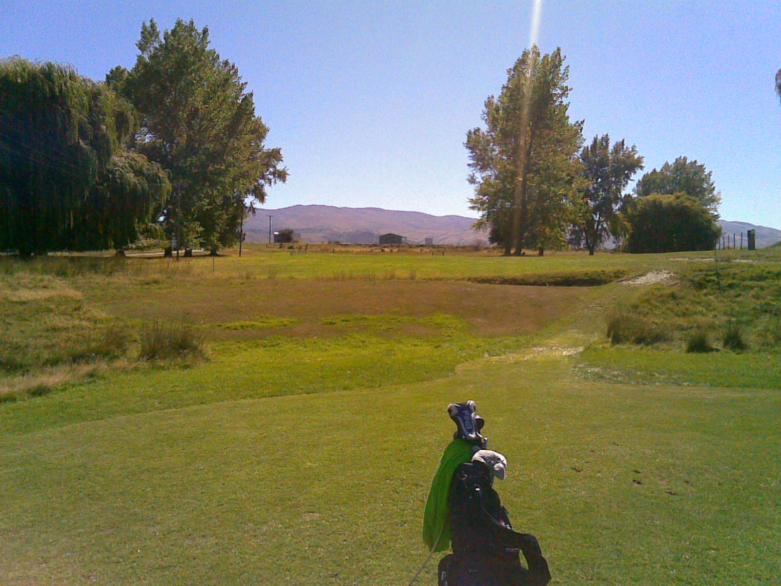 First hole par 3 at Tarras Golf Club with mountains in background Otago New Zealand