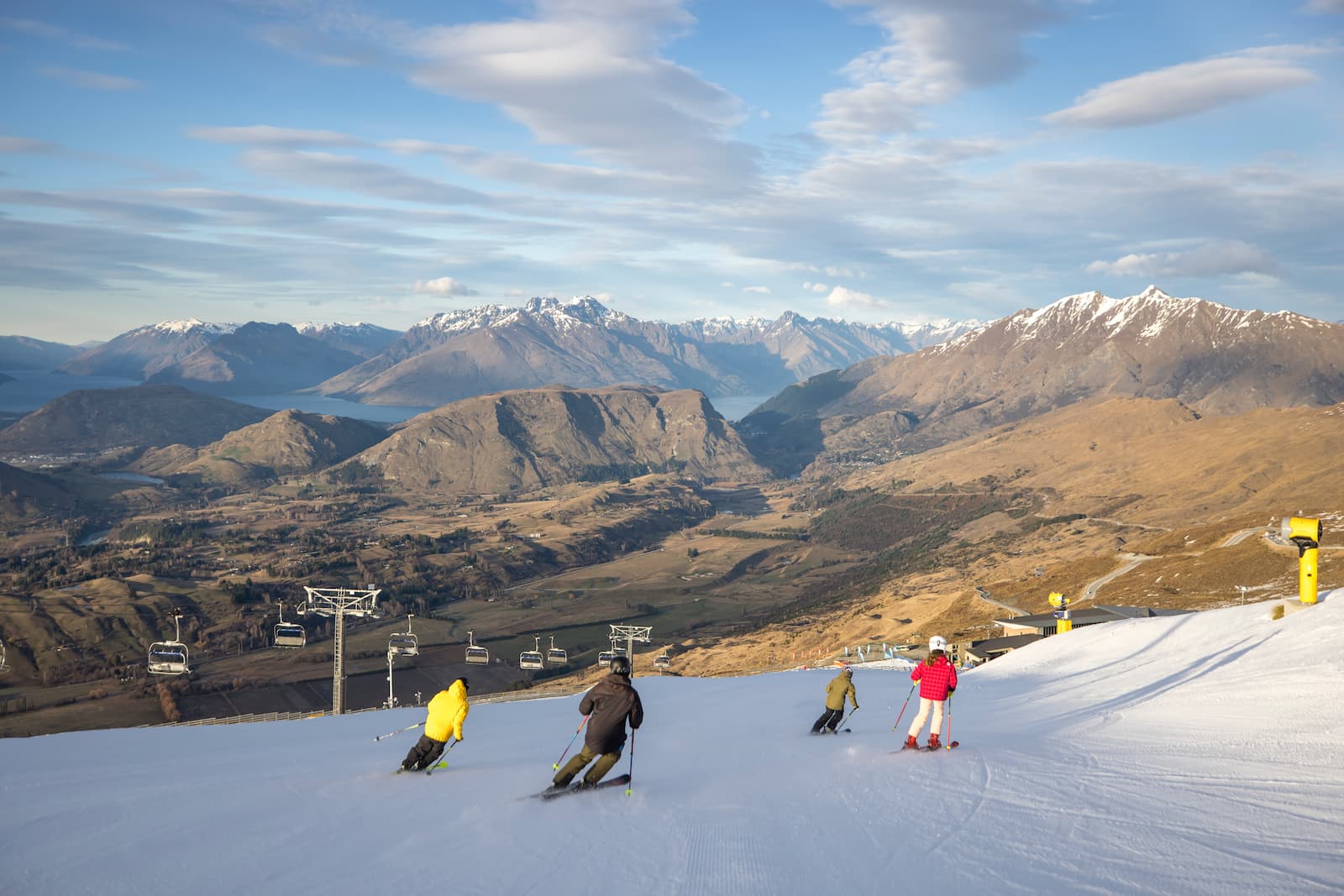 Family skiing at Coronet Peak with Remarkables and Lake Wakatipu Queenstown