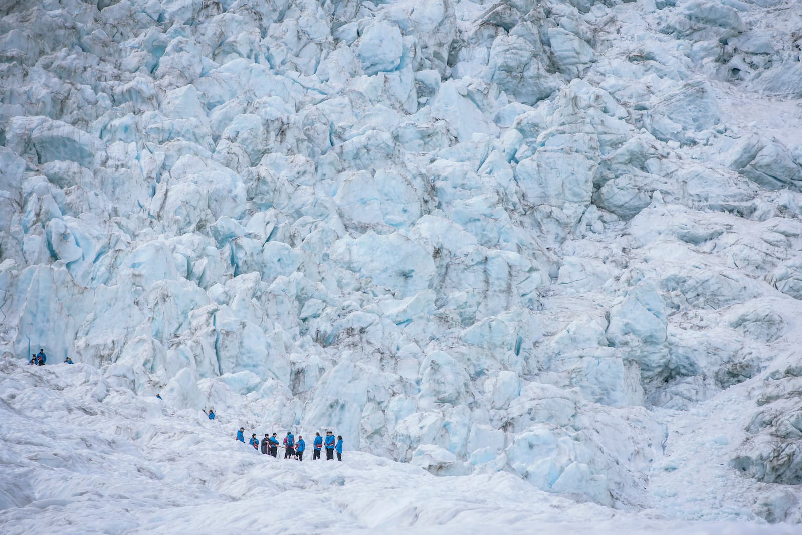 Hiker inside blue ice cave on Franz Josef Glacier West Coast