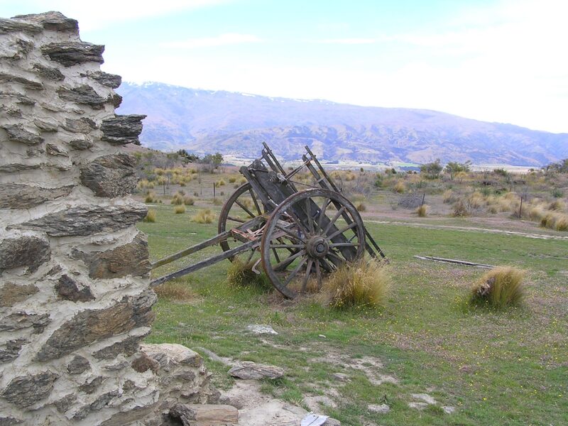 Bendigo gold mining ruins with old cart and snow-capped mountains Central Otago New Zealand
