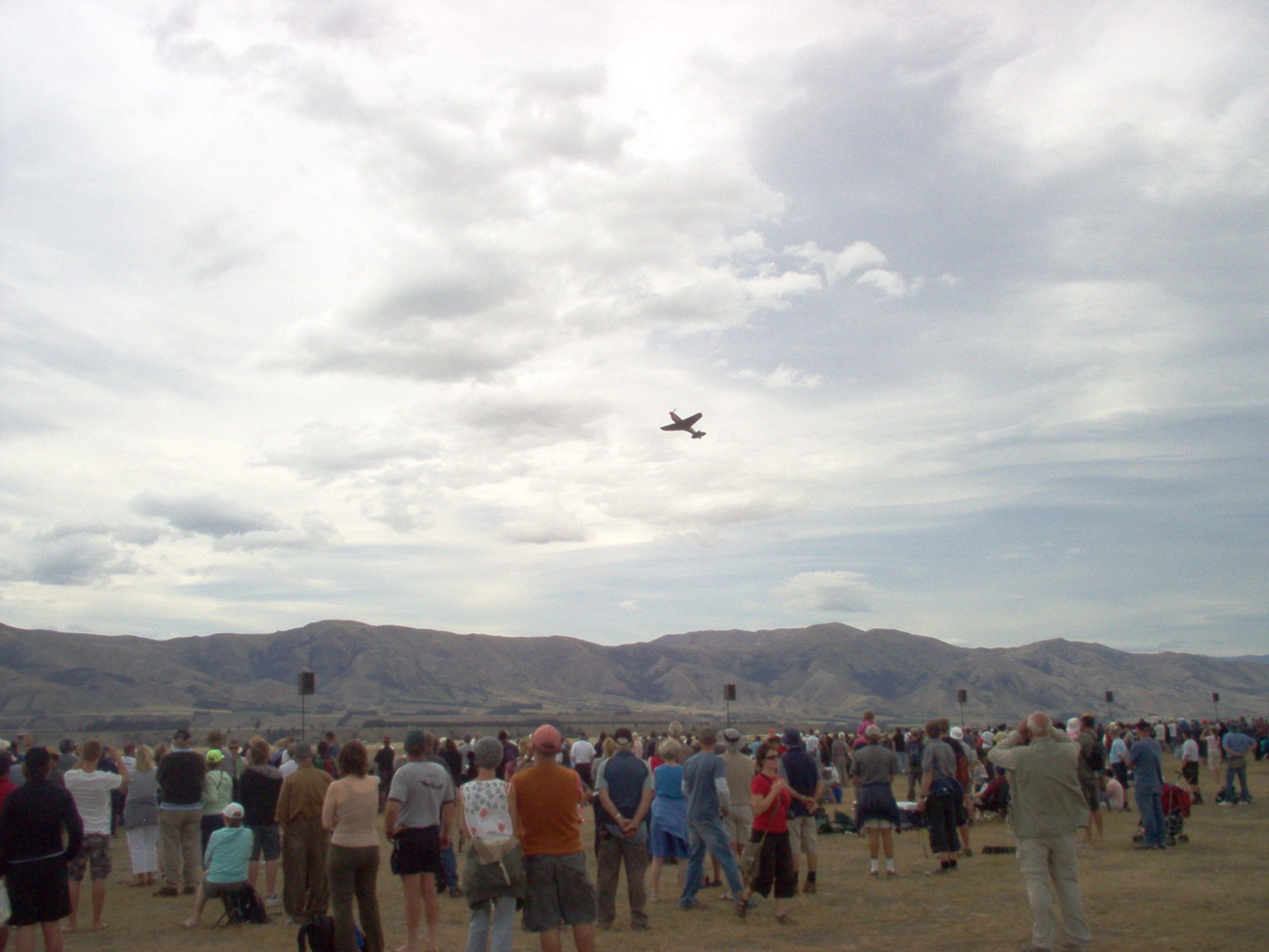 Crowds watching a P-51 Mustang fly over at Warbirds Over Wanaka airshow New Zealand
