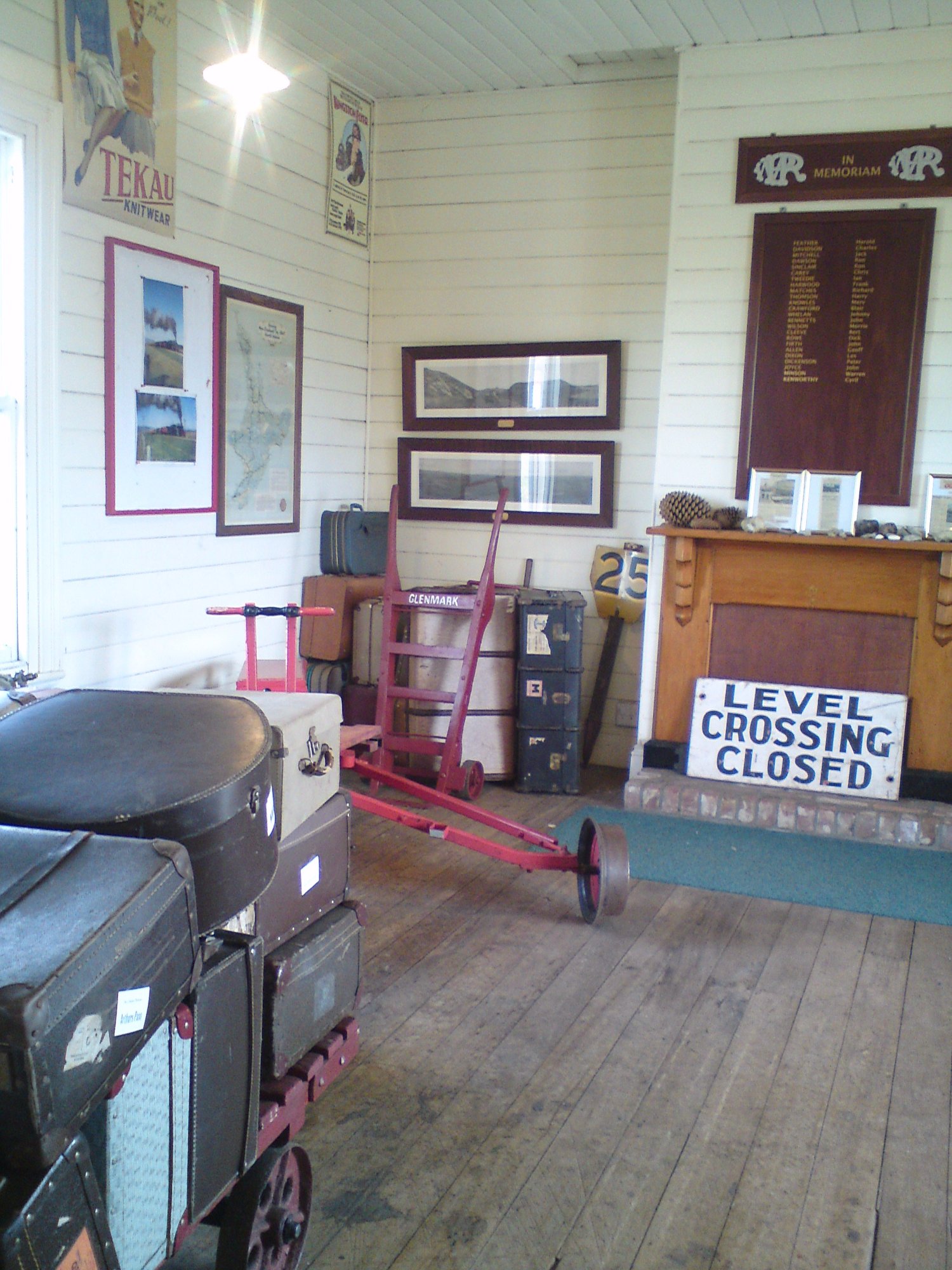 Inside Glenmark Station with vintage luggage, railway memorabilia and Level Crossing Closed sign